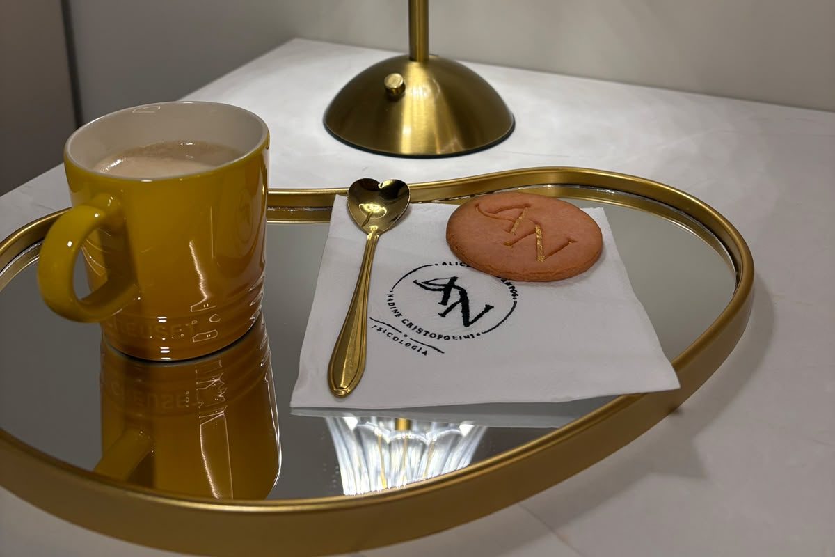 Café servido no consultório, com biscoito com o monograma